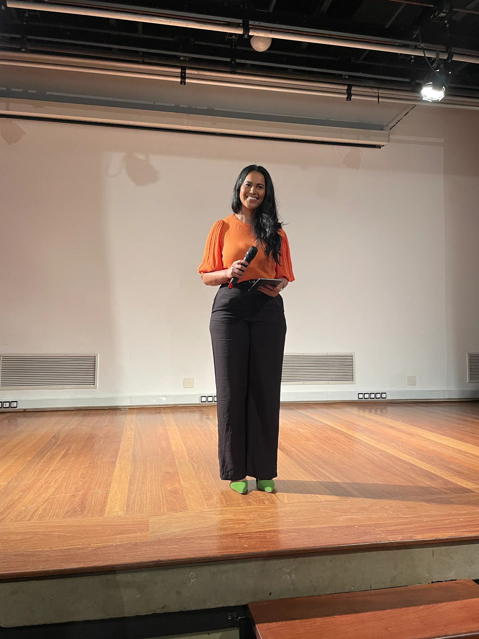 Janice Correia no palco durante uma palestra de comunicação e oratória